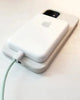 Uni•Magsafe wireless battery pack charging an iPhone via a lightning cable, emphasizing its dual charging capability.
